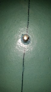 Hole in the foam insulation showing the shiny copper tank